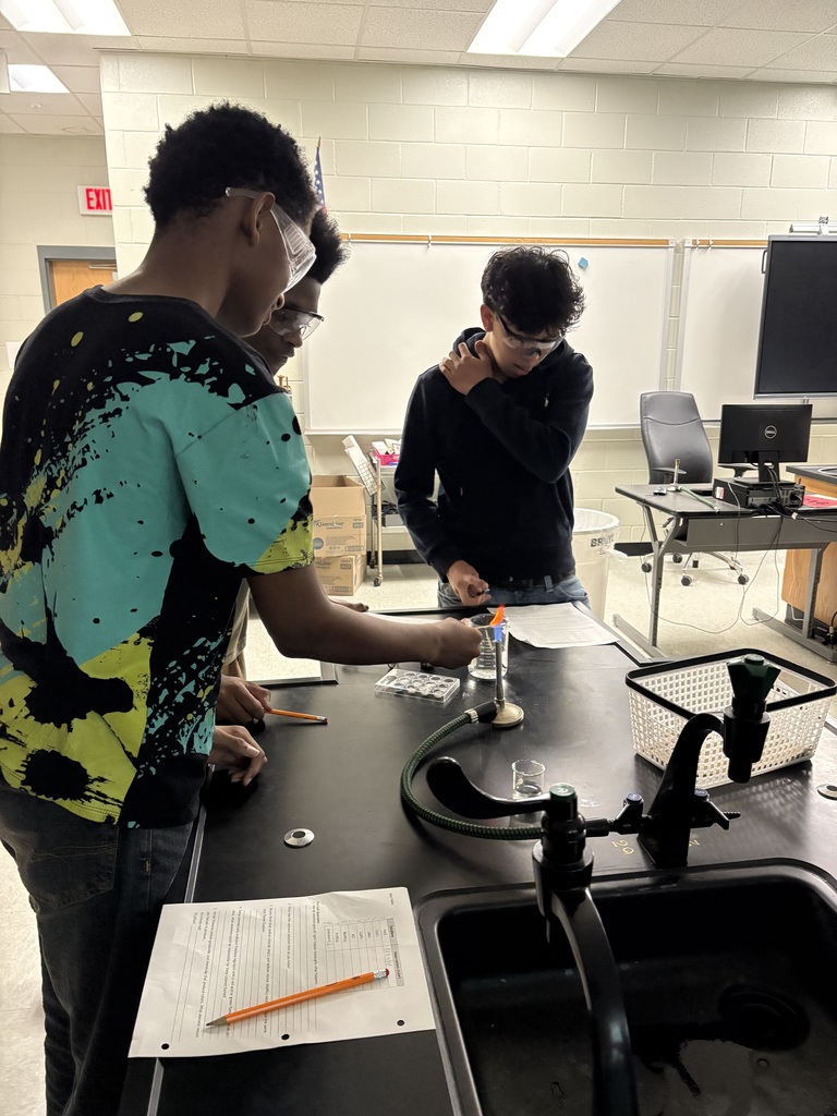 3 male students working with chemistry set in lab.