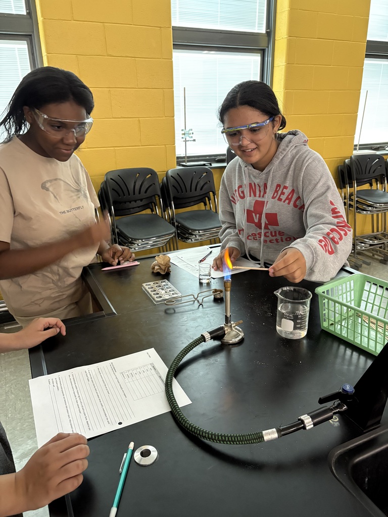 2 female students working in lab with flame.