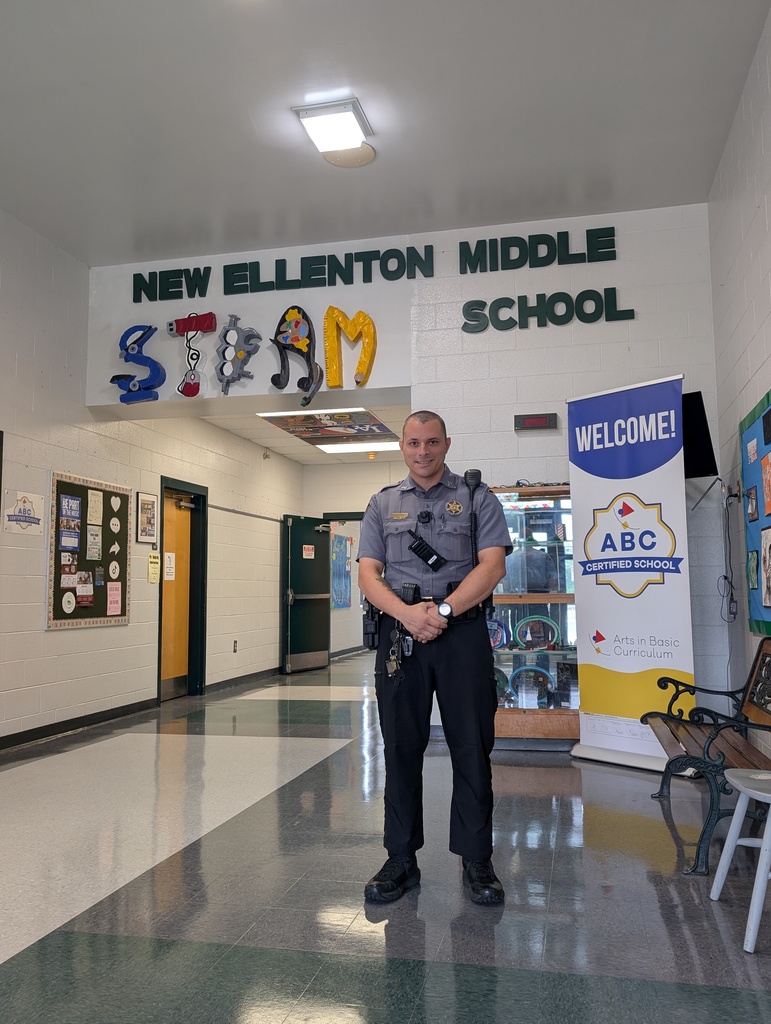 picture of SRO standing in front of school sign 