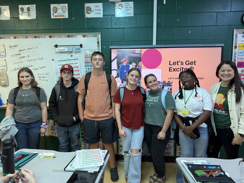 6 students and a teacher standing in front of a board