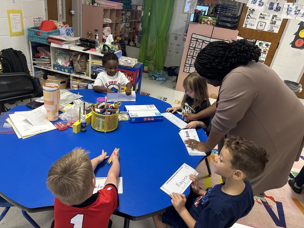 Students and teacher at table.