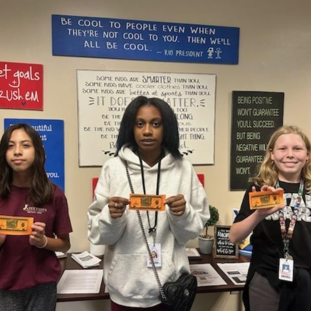 3 students holding coupons 
