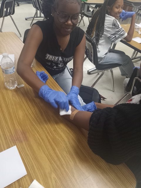 Nursing club students demonstrating first aid techniques.