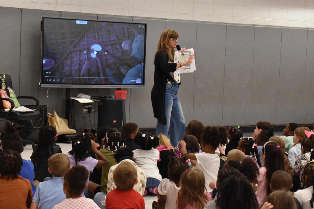 Speaker showing brochure to students.