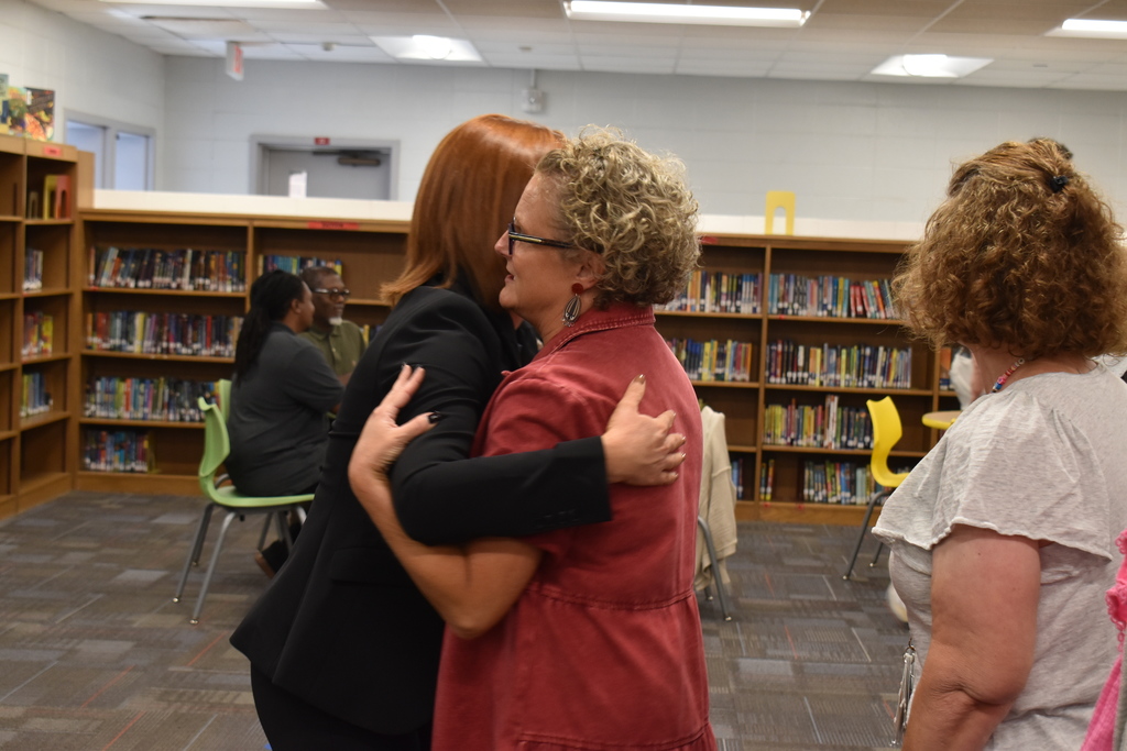 Two people hugging in library.