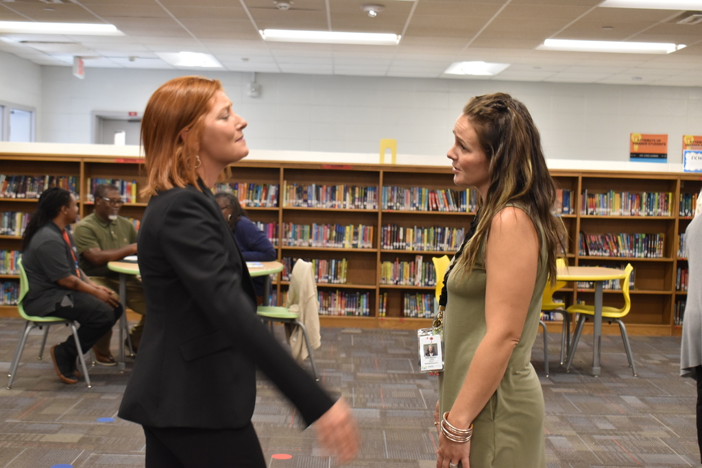 Teachers and principal standing in library.