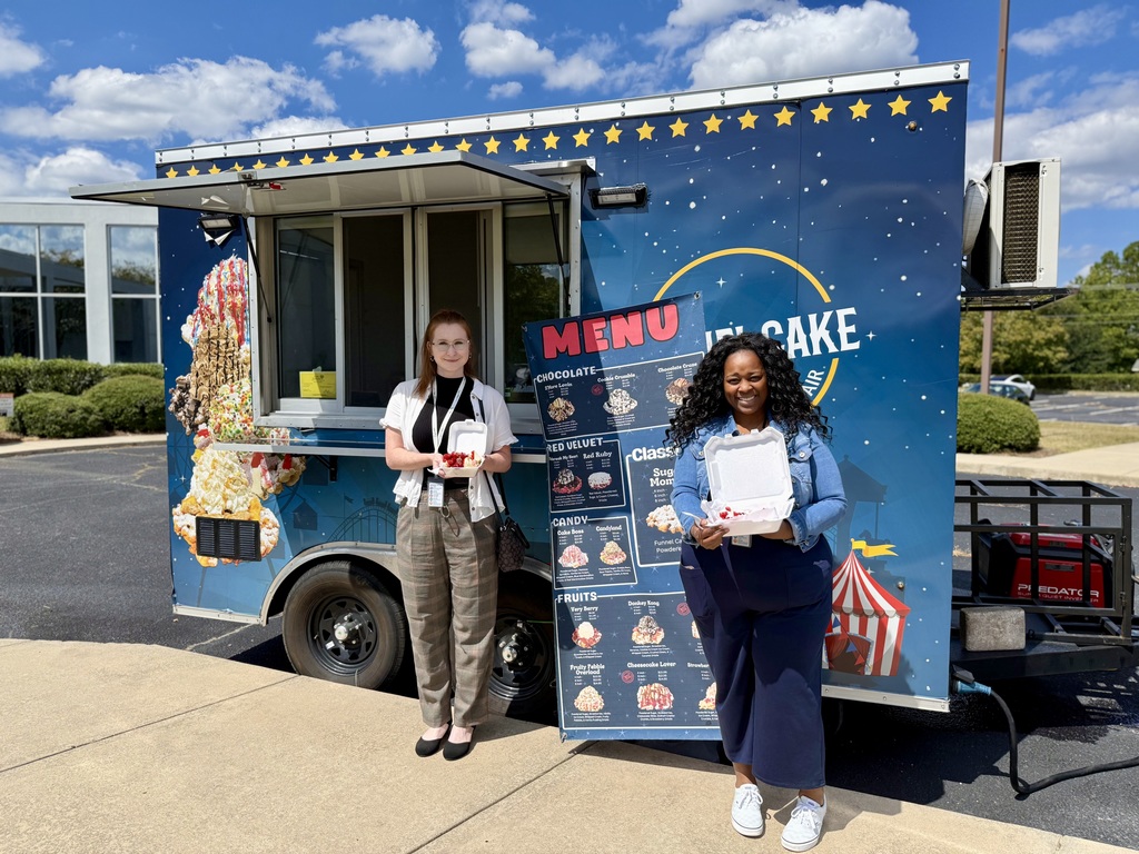 Two ACPSD Staff members with funnel cakes in front of food truck.