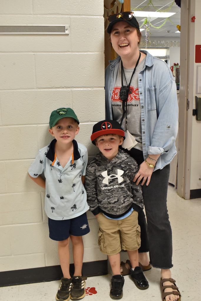 Students  and teacher wearing hats at school.
