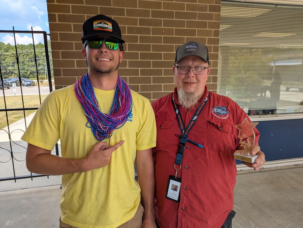 Student with instructor and tropy