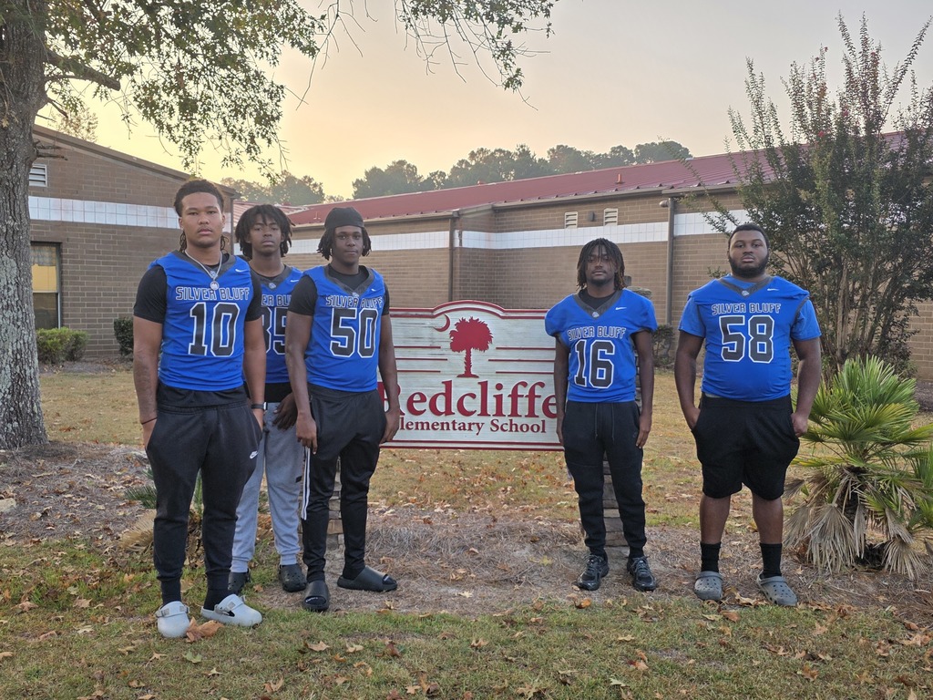 Football players at Redcliffe sign.