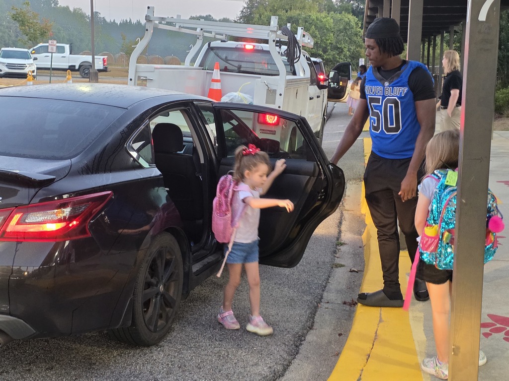 Football player opening car door.