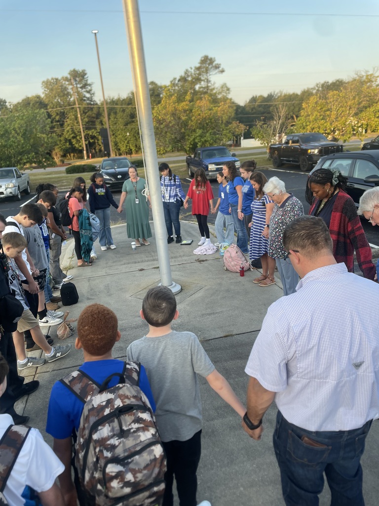 Students, staff and community members praying at the pole.