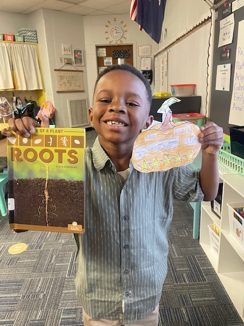 Student holding a book and pumpkin book review