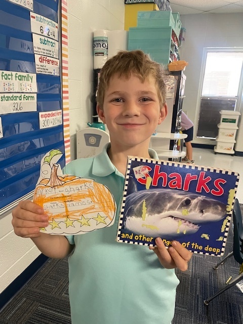Student holding a book and pumpkin book review