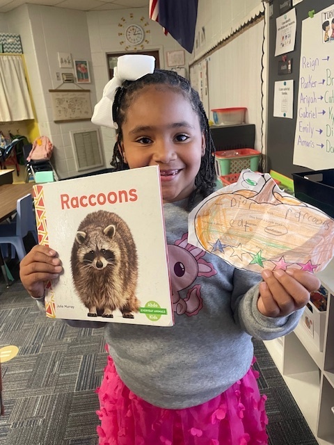Student holding a book and pumpkin book review