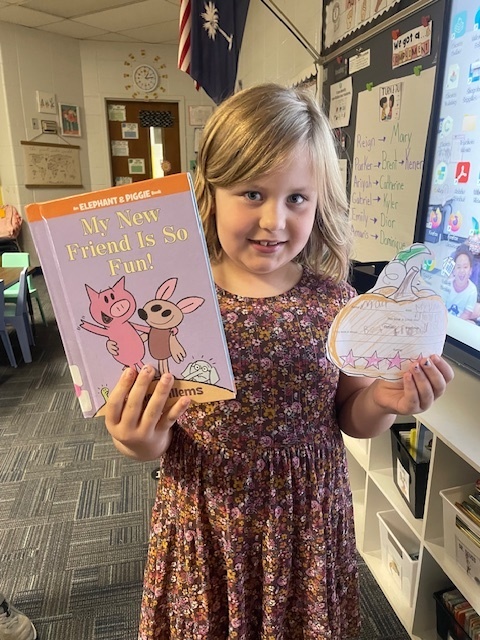 Student holding a book and pumpkin book review