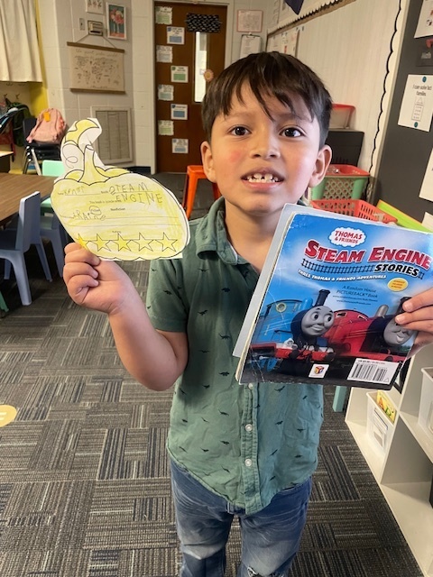 Student holding a book and pumpkin book review