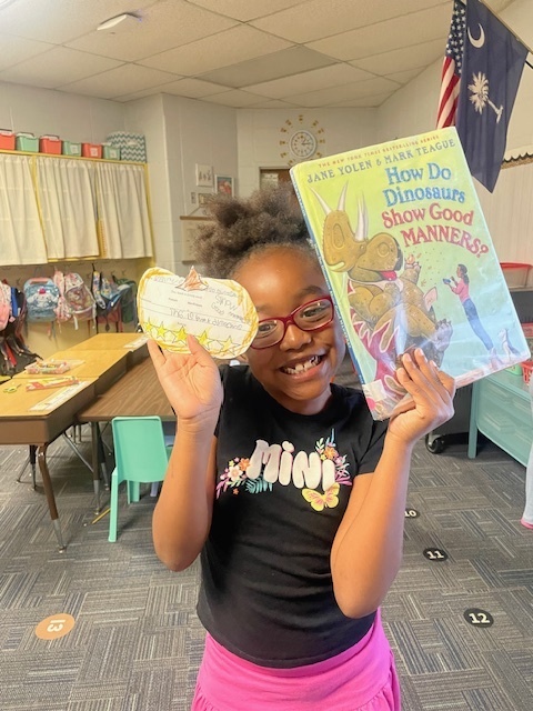 Student holding a book and pumpkin book review