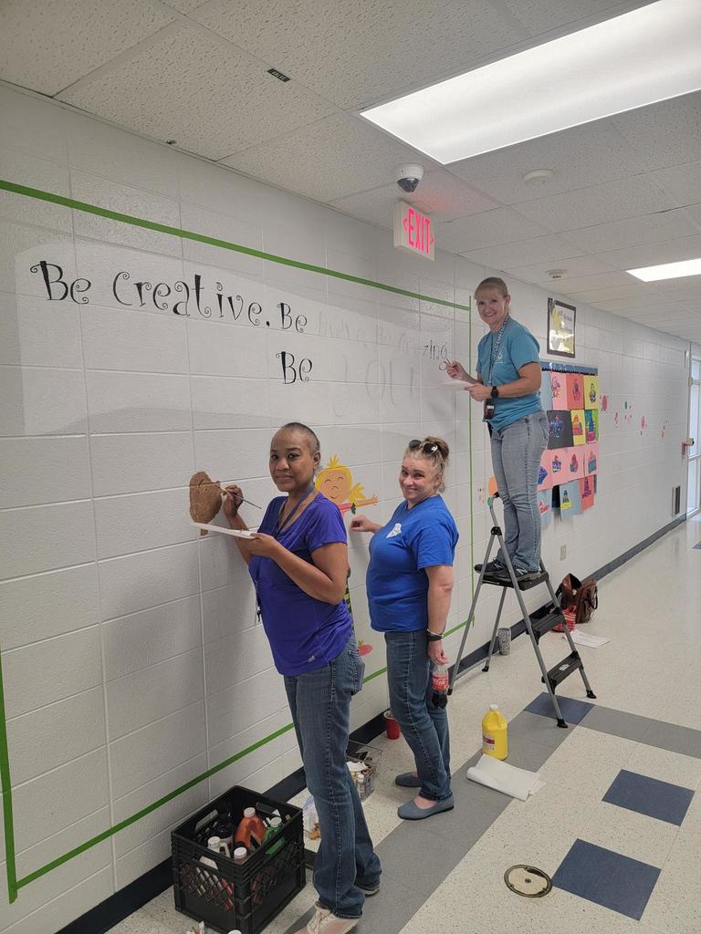 Teachers working on New back hallway mural “Be Creative. Be Brave. Be Amazing. Be You!” Three students are pictured shining with confidence, encouraging all of us to embrace who we are.