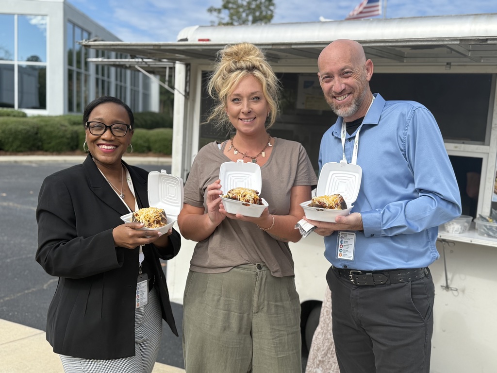 Three staff members with with spuds.