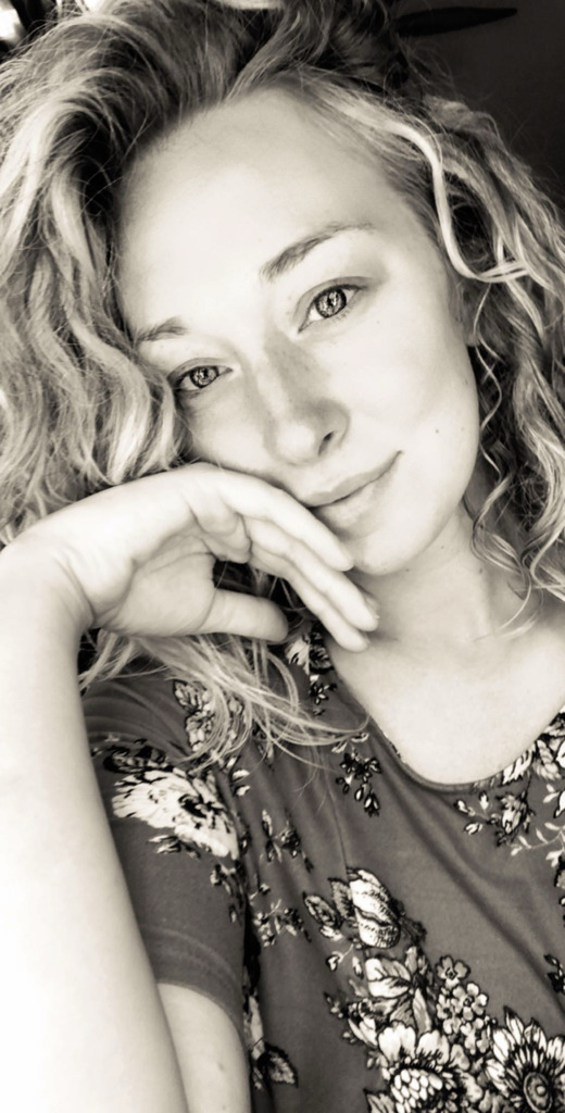 Black and White photo of a smiling woman. 