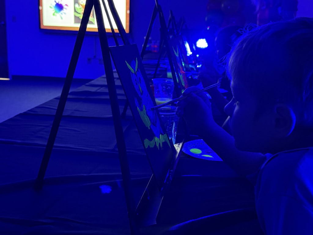 Students paint glow in the dark paintings. 