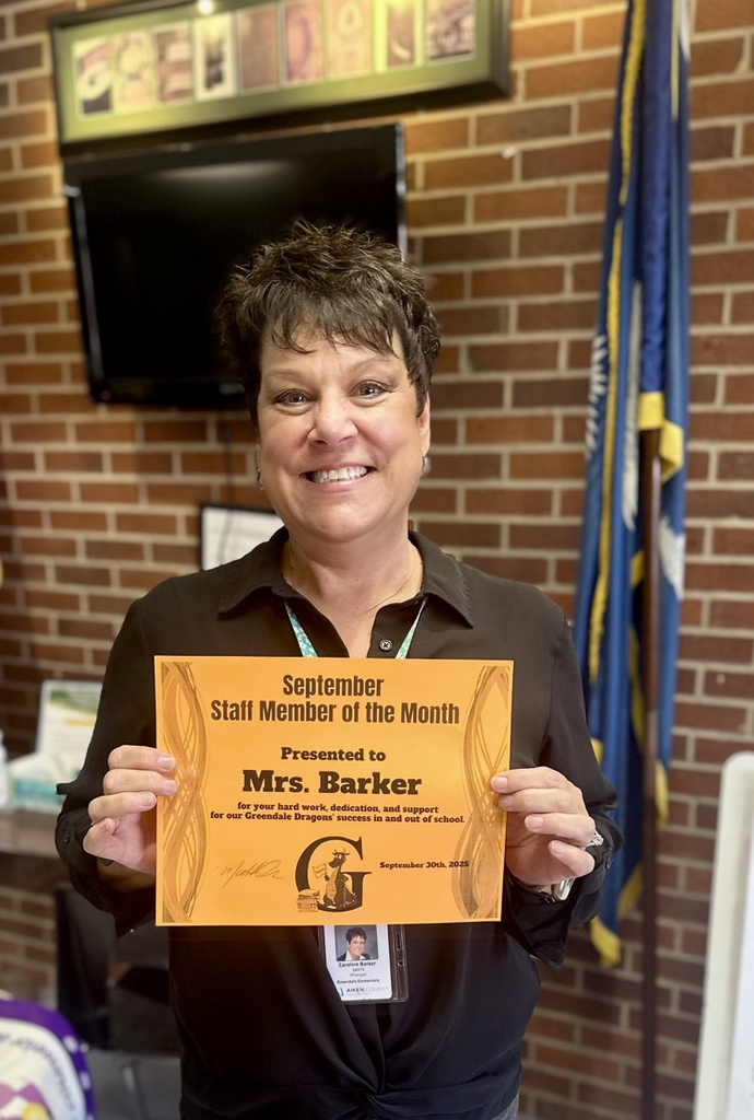 Mrs. Bsrker holding a staff member of the month certificate 