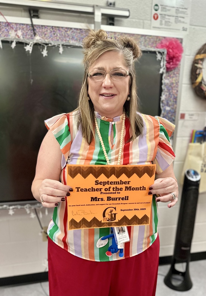 Mrs. Burrell holding a teacher of the month certificate 