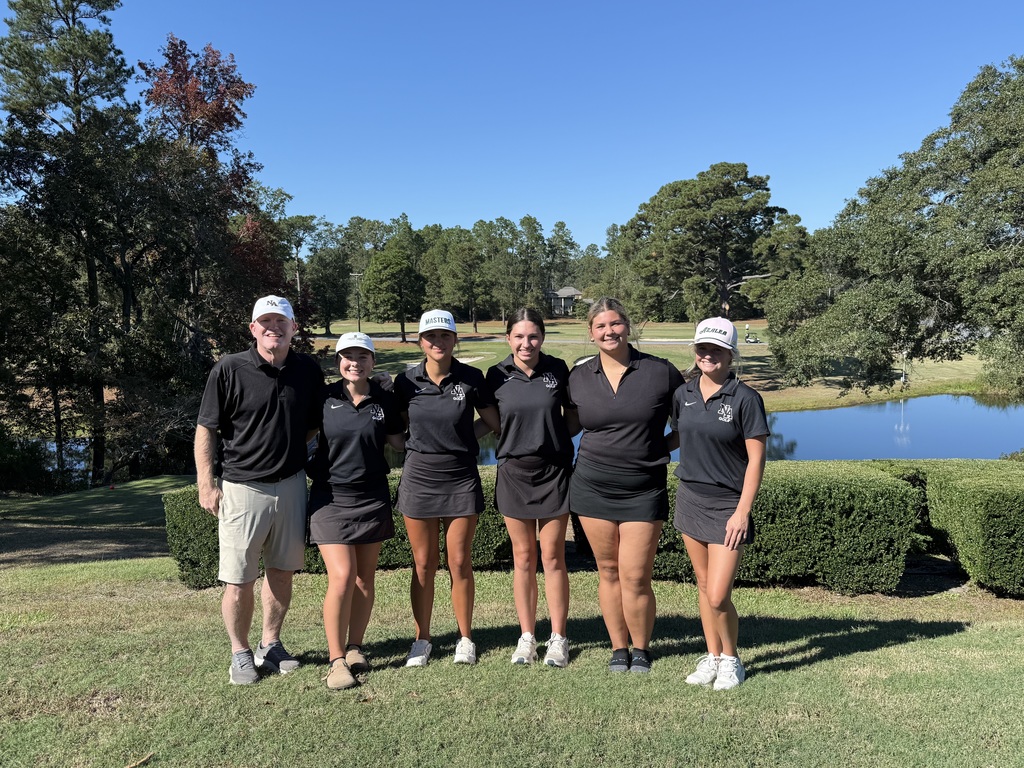 Girls Golf Team with Coach on Golf Course with pond in background.