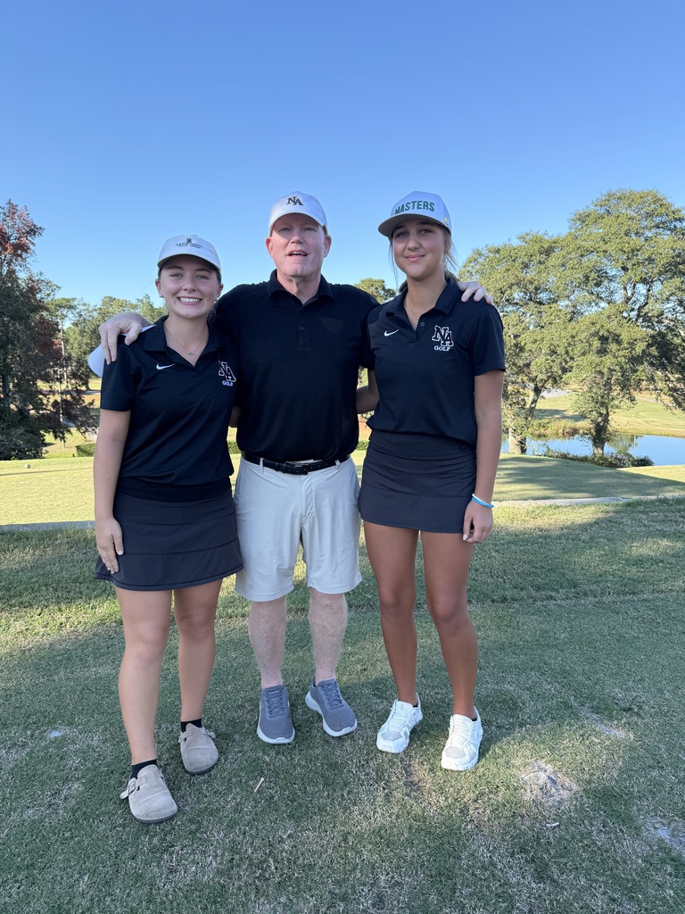 2 Girl golfers with coach on course with pond in background.