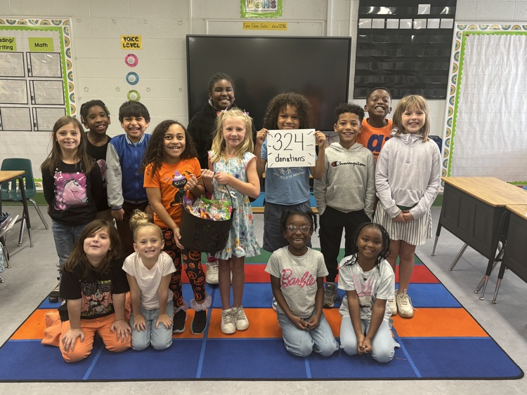 students holding a black cauldron of goodies