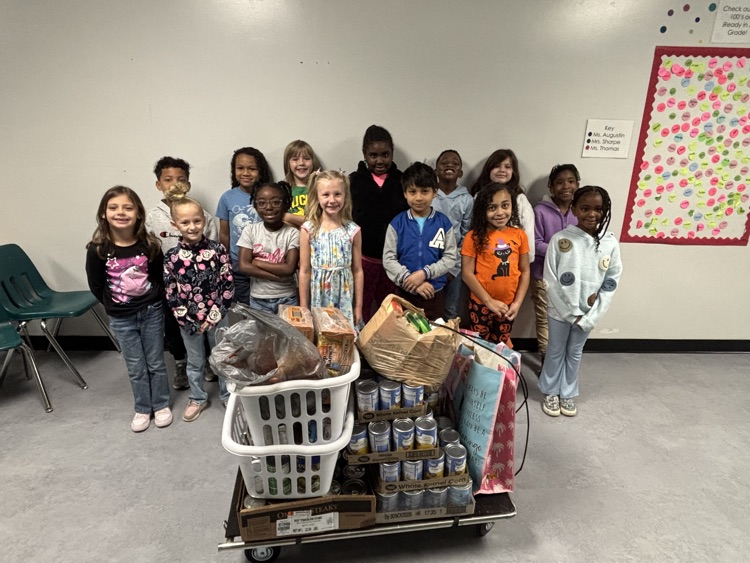 students standing behind canned good donations 