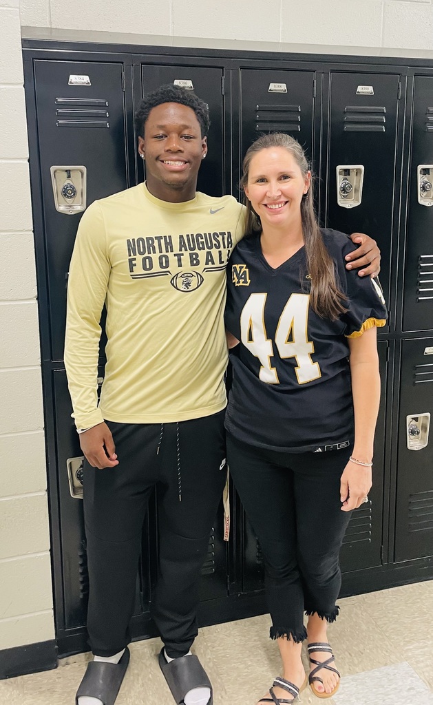 Teacher with football jersey and senior football player.