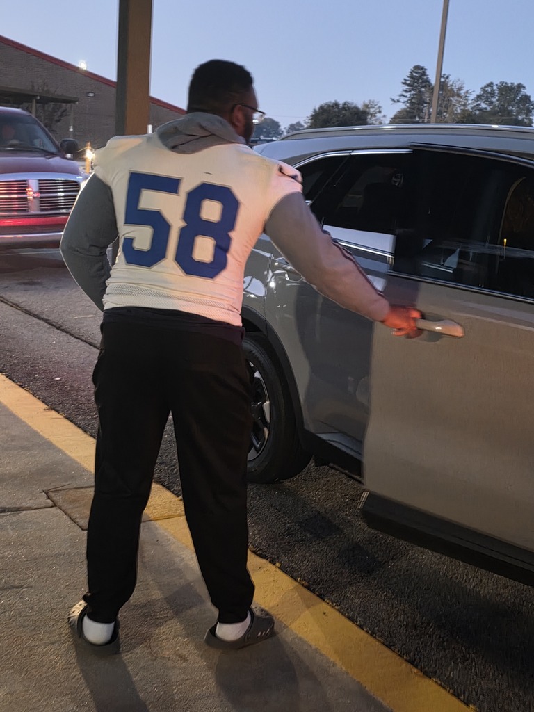 Football player opening car door.