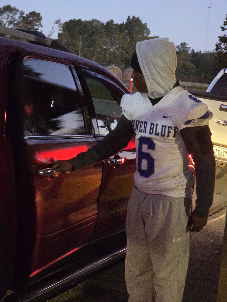 Football player opening car door.