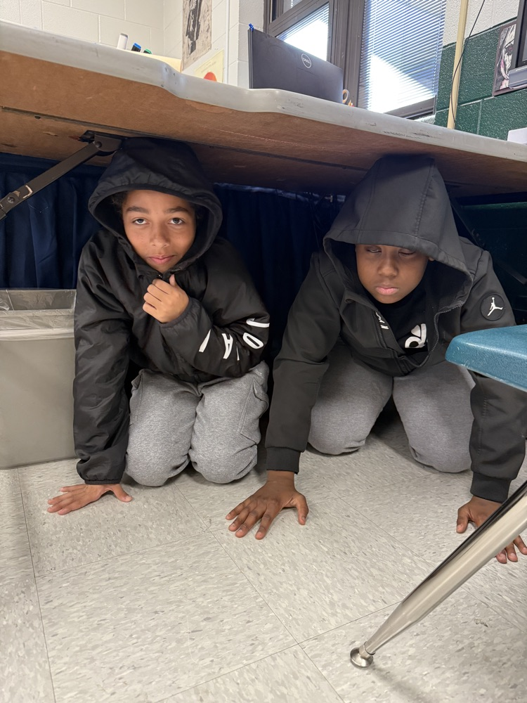 students under a desk 