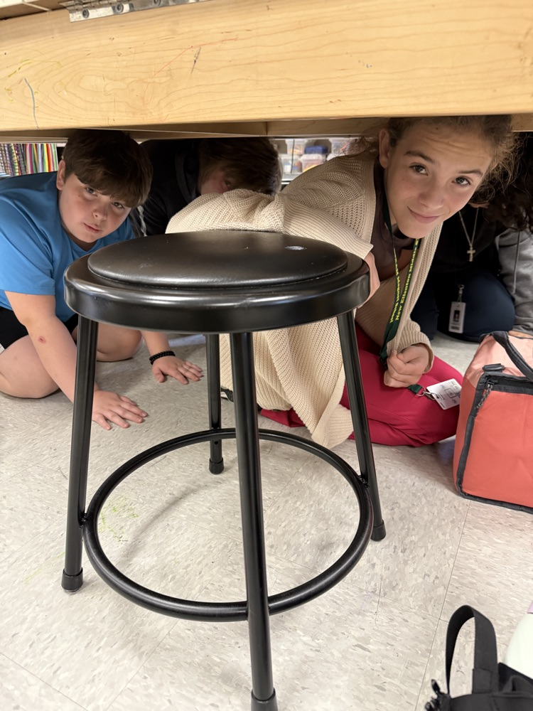 students under a desk 
