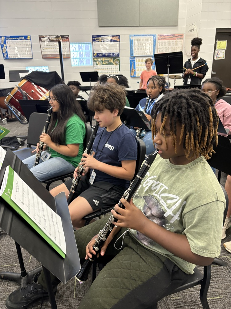 students sitting in a band class playing band instruments 