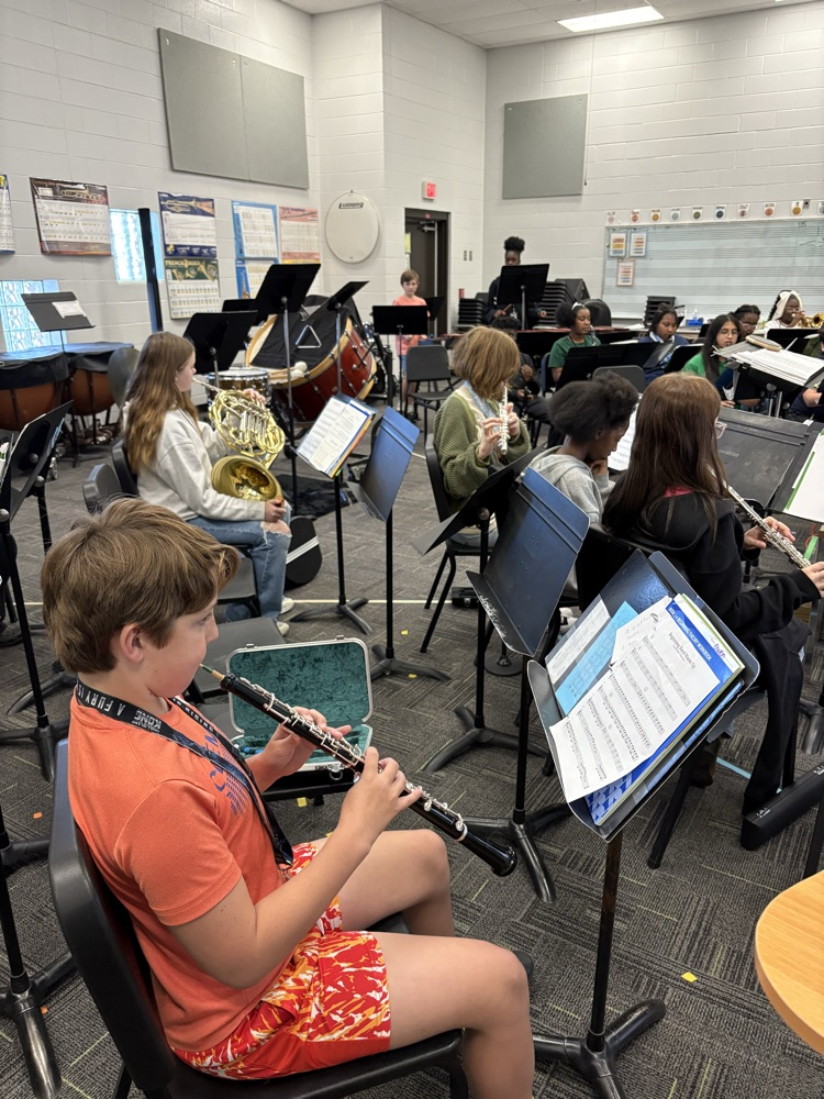 students sitting in a band class playing band instruments 