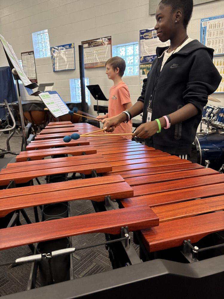 students sitting in a band class playing band instruments 