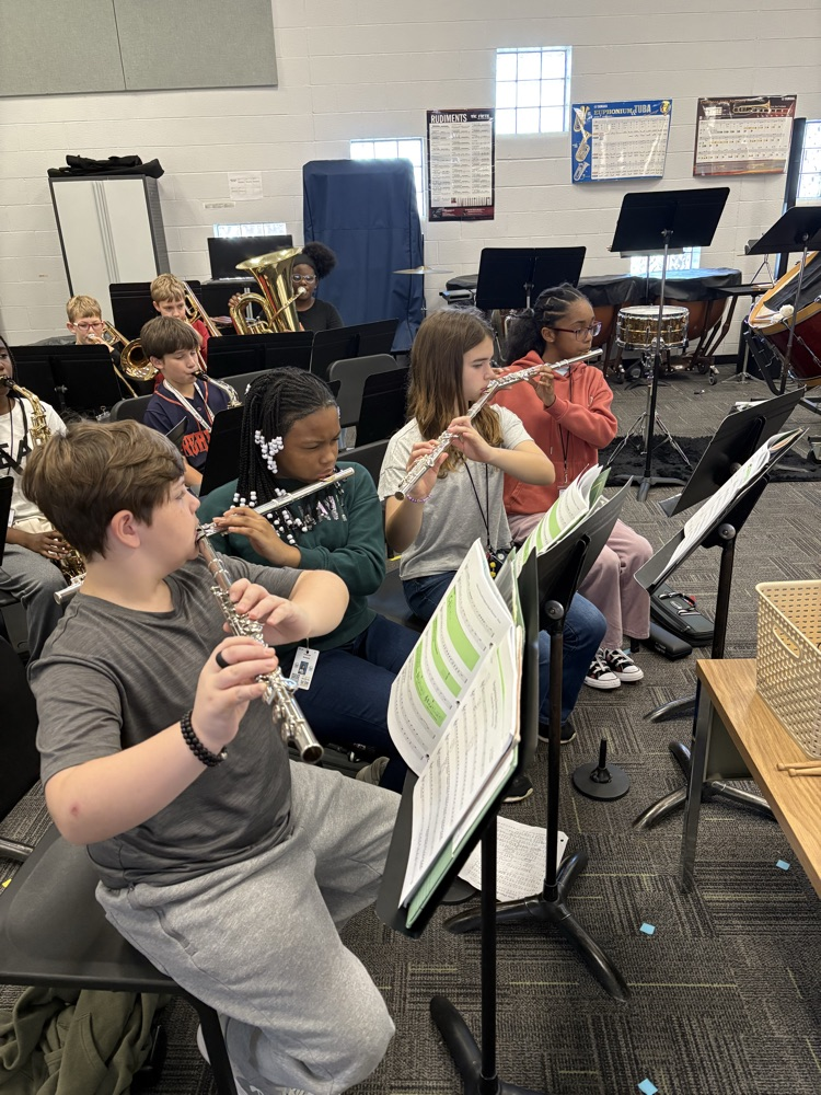 students sitting in a band class playing band instruments 