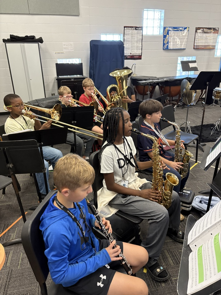 students sitting in a band class playing band instruments 