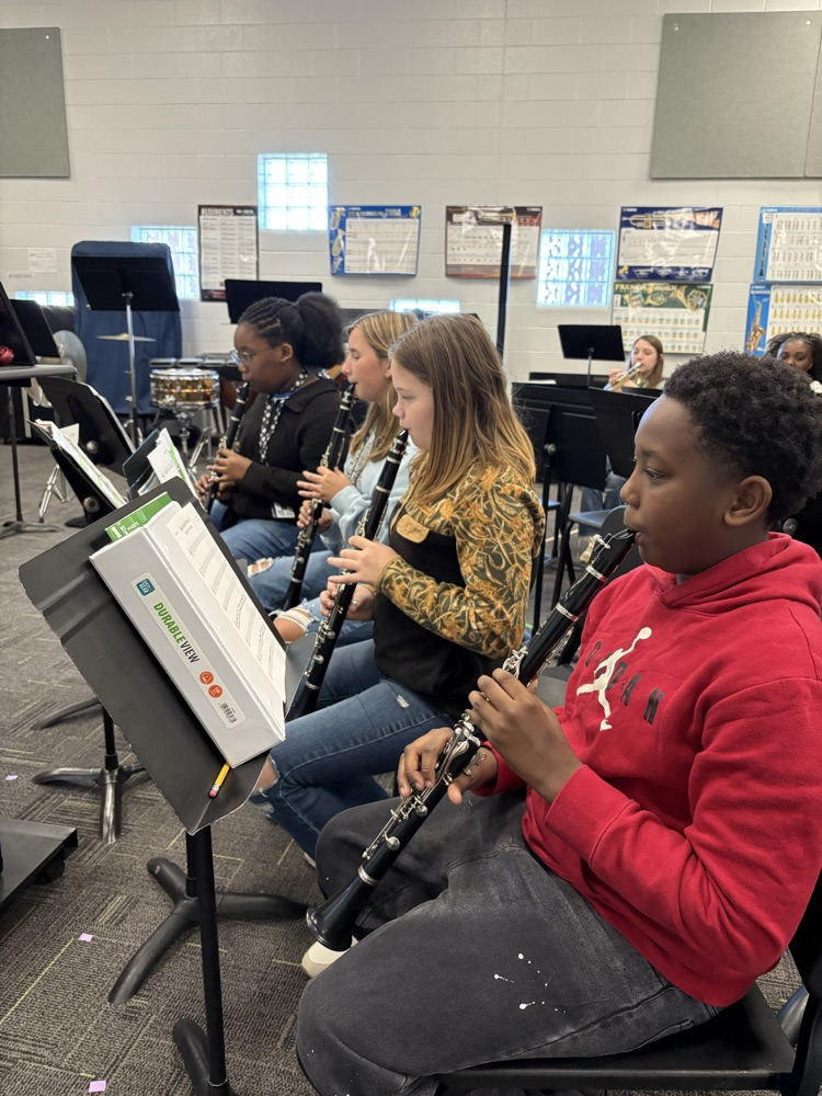 students sitting in a band class playing band instruments 