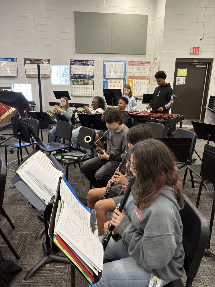 students sitting in a band class playing band instruments 