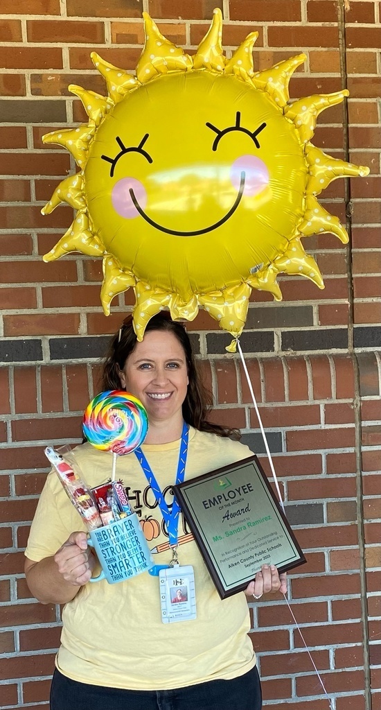 Mrs. Ramirez holding an employee of the month award.