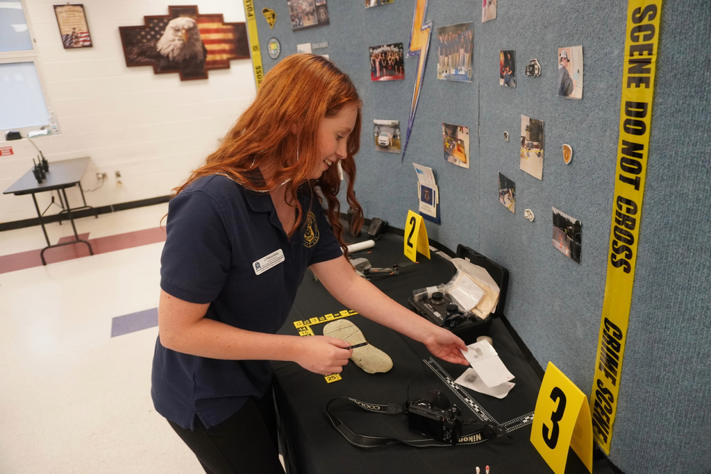Photo of a student displaying Forensic Science items during Community Night at ACCTC.