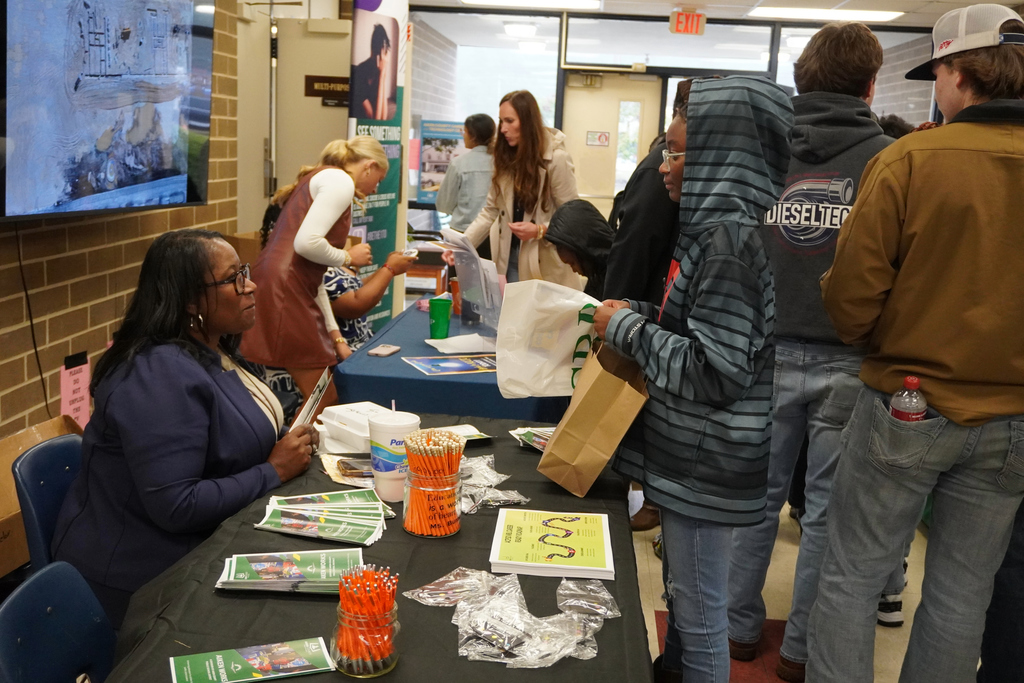 Guests visiting the Aiken Works information table. 