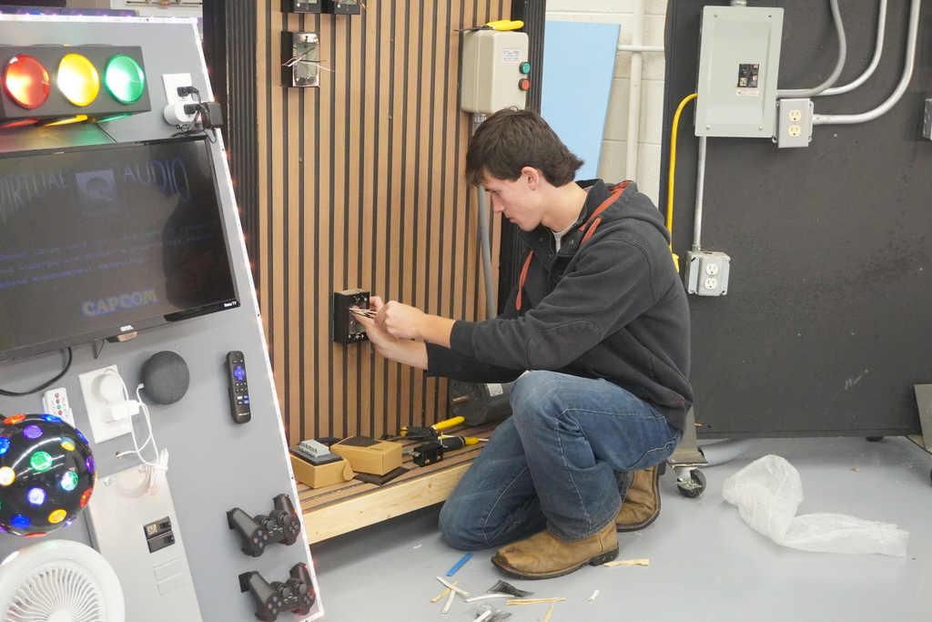 Student showcasing electrical skills in a classroom at Community Night at ACCTC.