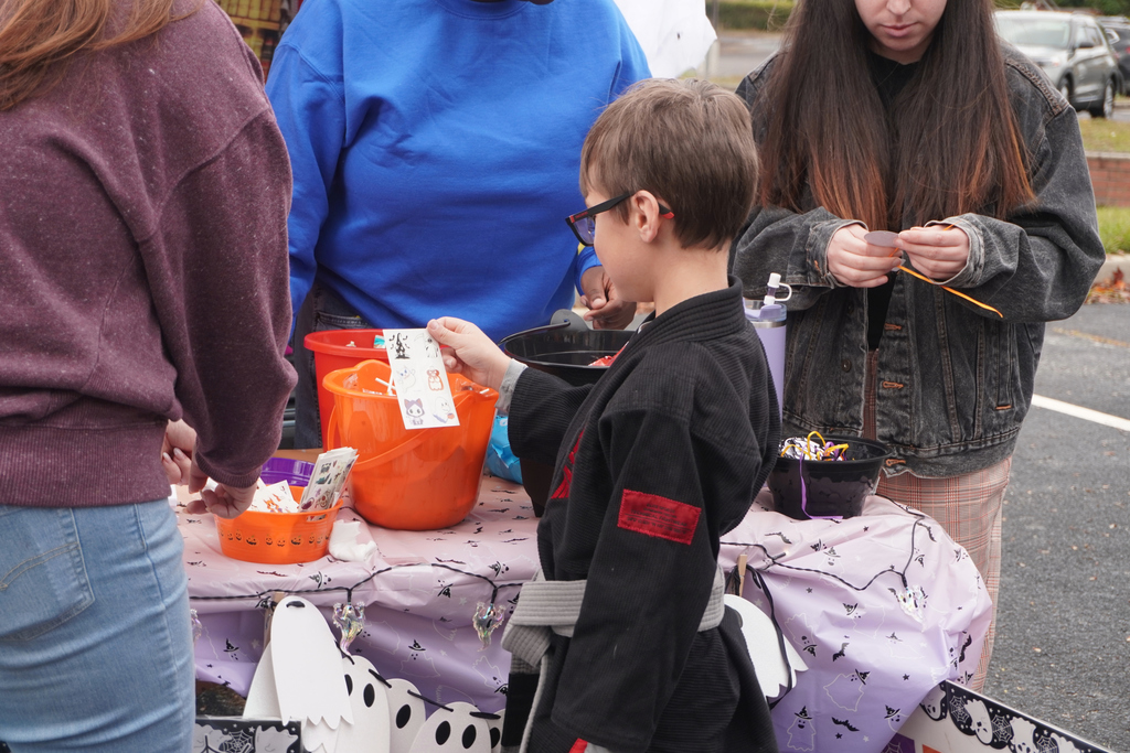 Student dressed in karate attire looking at stickers.