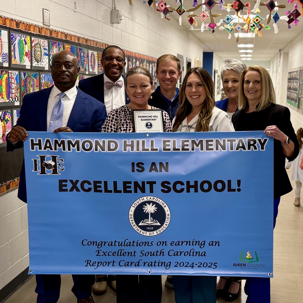 District Leadership and Hammond Hill Elementary administrators posing with Excellent School banner.